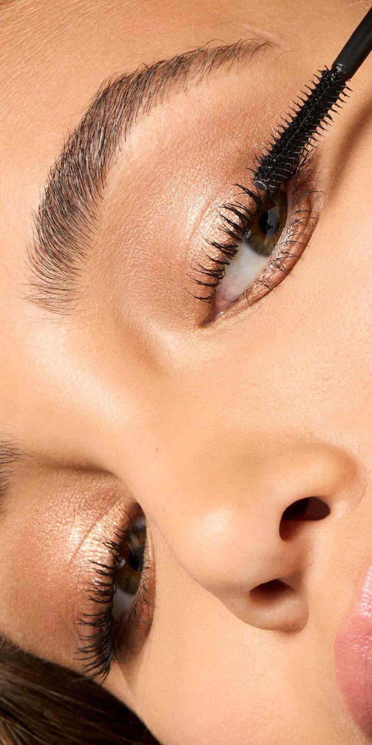 Woman applying Mary Kay Great Heights Waterproof Mascara to her lashes