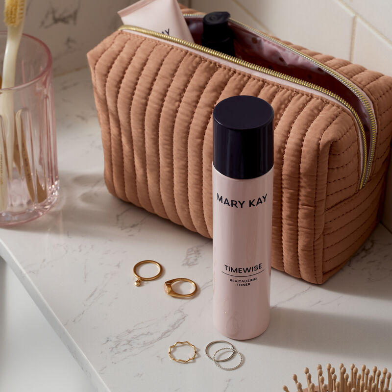 Toner atop a marble countertop surrounded by jewelry and beauty essentials
