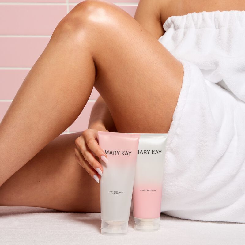 Mary Kay 2 in 1 Body Wash  Shave and Mary Kay Hydrating Lotion held beside bent legs against a light pink background