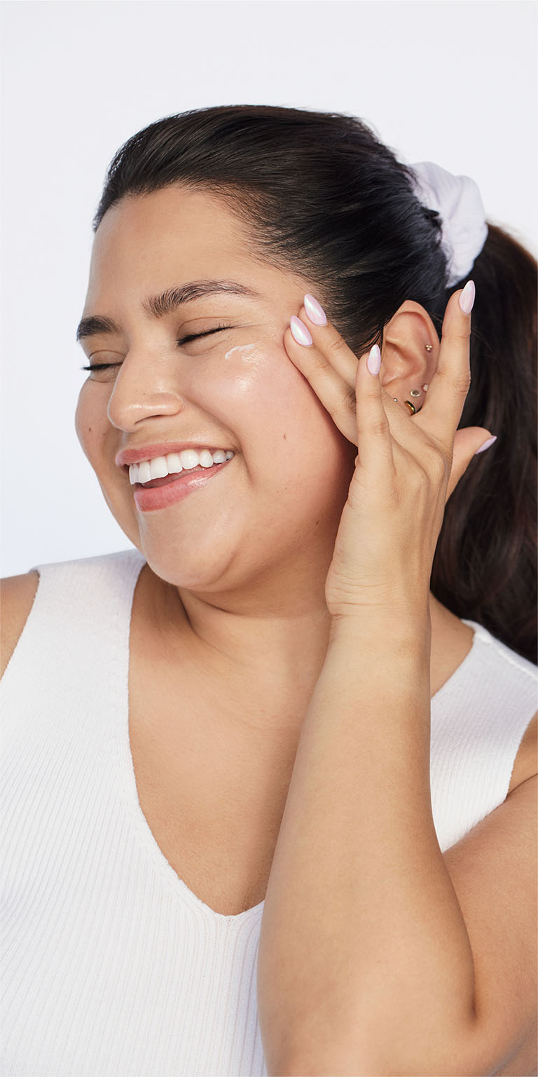 Woman applying Mary Kay Mineral Facial Sunscreen Broad Spectrum SPF 30 to the side of her cheek